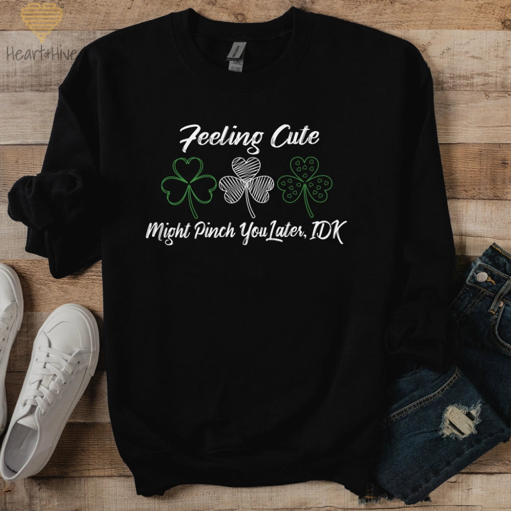 Black sweatshirt with three delicate shamrock outlines saying 'Feeling cute might pinch you later, idk'.