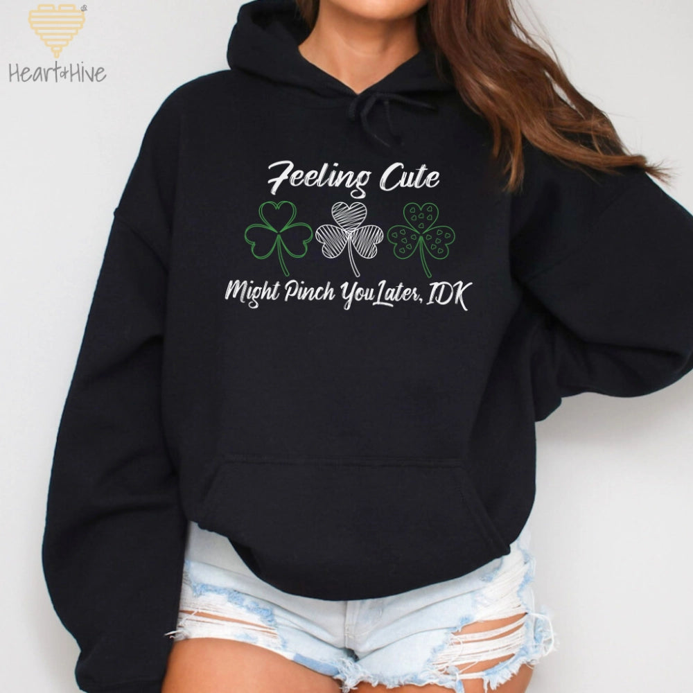 Black hoodie with three delicate shamrock outlines saying, 'Feeling cute might pinch you later, idk'.