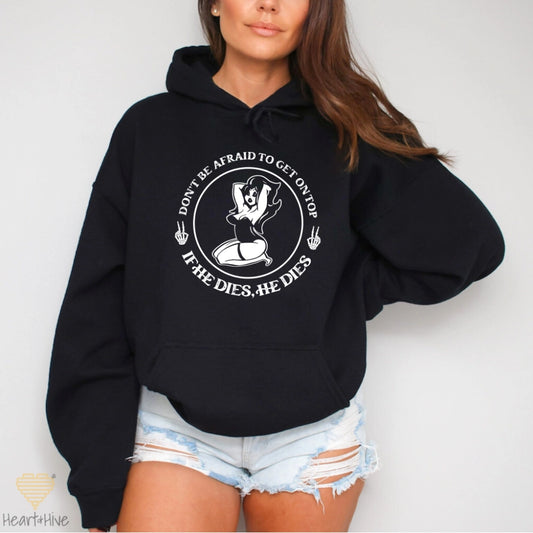 Black hoodie with a circular design featuring a pin-up style woman, two skull hand peace signs, and the phrase 'Don't be afraid to get on top, if he dies, he dies.