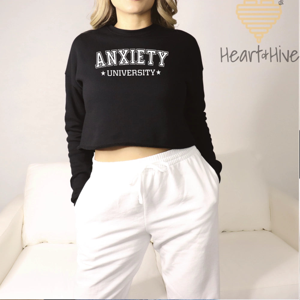 Black cropped fleece sweatshirt with 'Anxiety University' in bold, white collegiate font, framed by small stars.