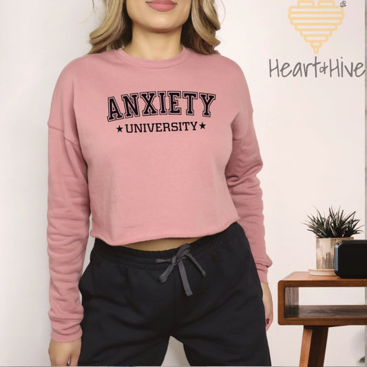 Mauve cropped fleece sweatshirt with 'Anxiety University' in bold, white collegiate font, framed by small stars.