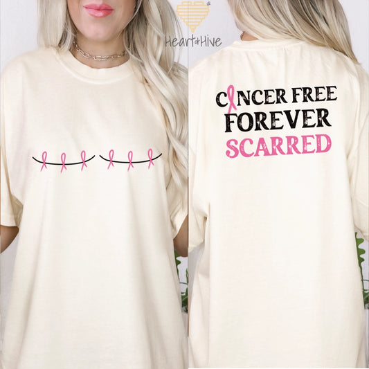 Ivory Comfot Color tee with two mastectomy scars with pink ribbons through scar lines. The back says Cancer Free Forever Scarred with a pink ribbon in place of the A in Cancer.