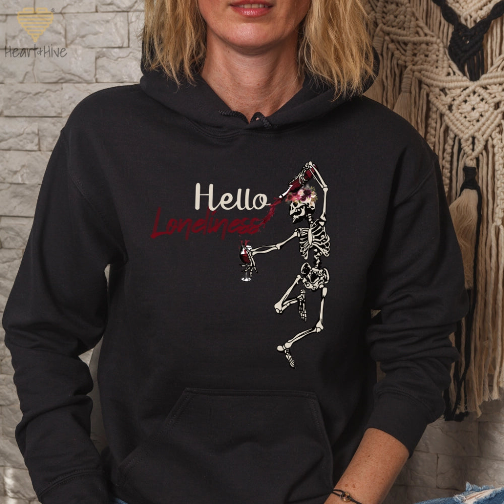 Black hoodie with a leaping skeleton holding a bottle of wine, splattering red liquid across 'Hello Loneliness' in bold and script fonts.